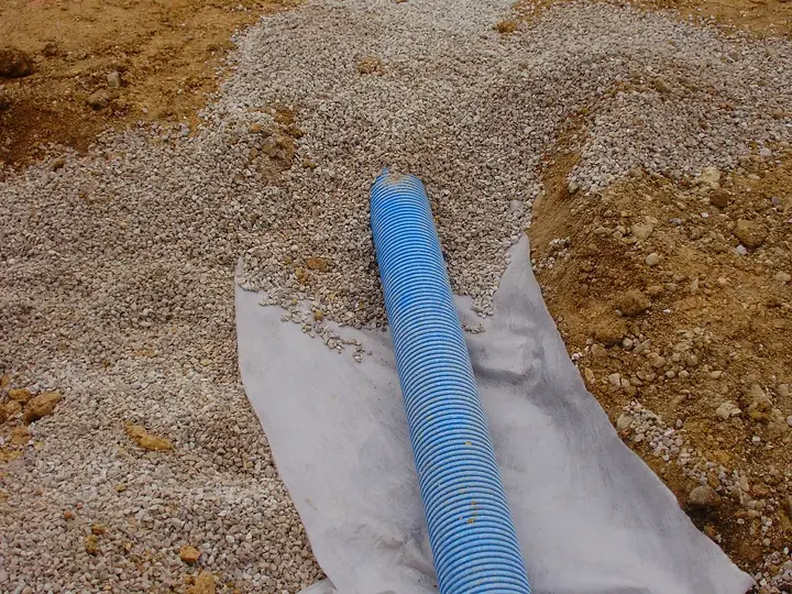 Drain posé dans le gravier sur géotextile